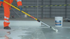 Applying Protectapeel FloorDefend by roller to a polished concrete floor to protect it during construction