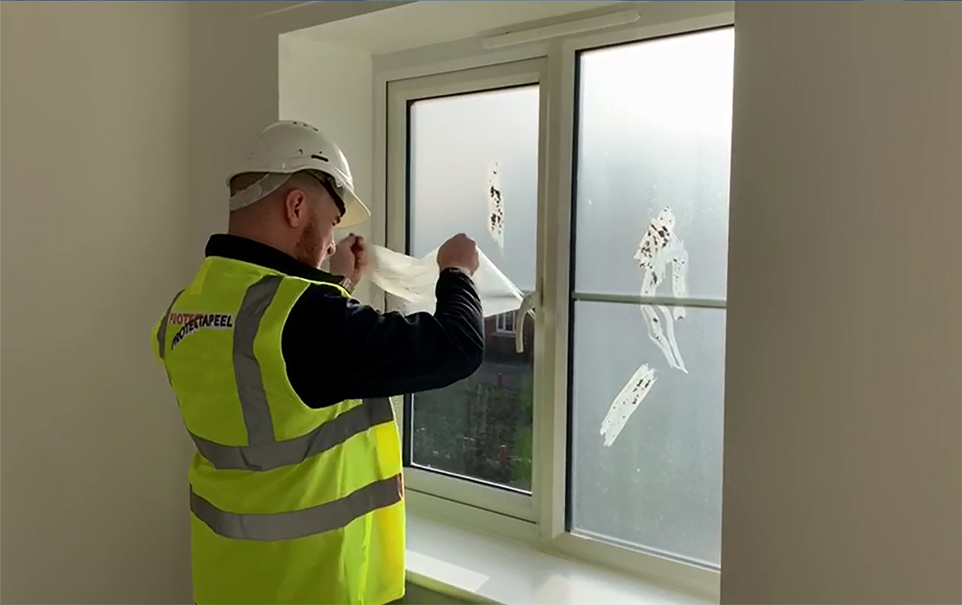 Peeling Protectapeel from a window, Protectapeel is recyclable reducing construction waste