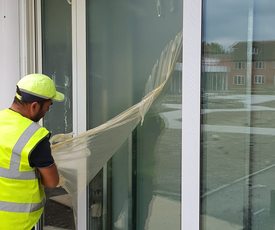 peeling Protectapeel from a window on a construction site