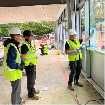 Protectapeel technician on a construction site explaining Protectapeel protective coatings for glass to construction workers
